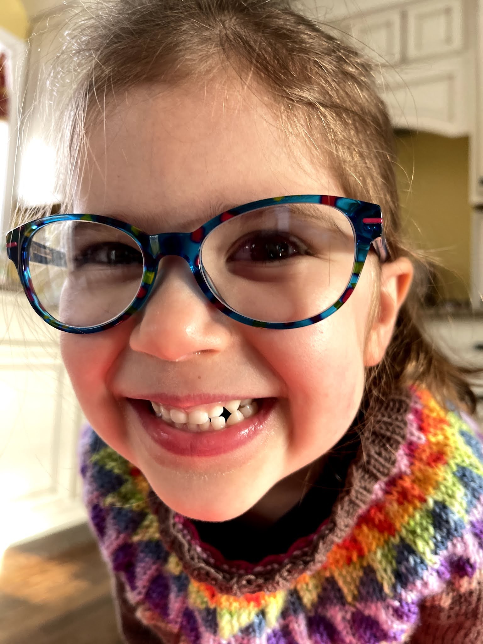 a little girl with a huge smile models her new hand knitted sweater